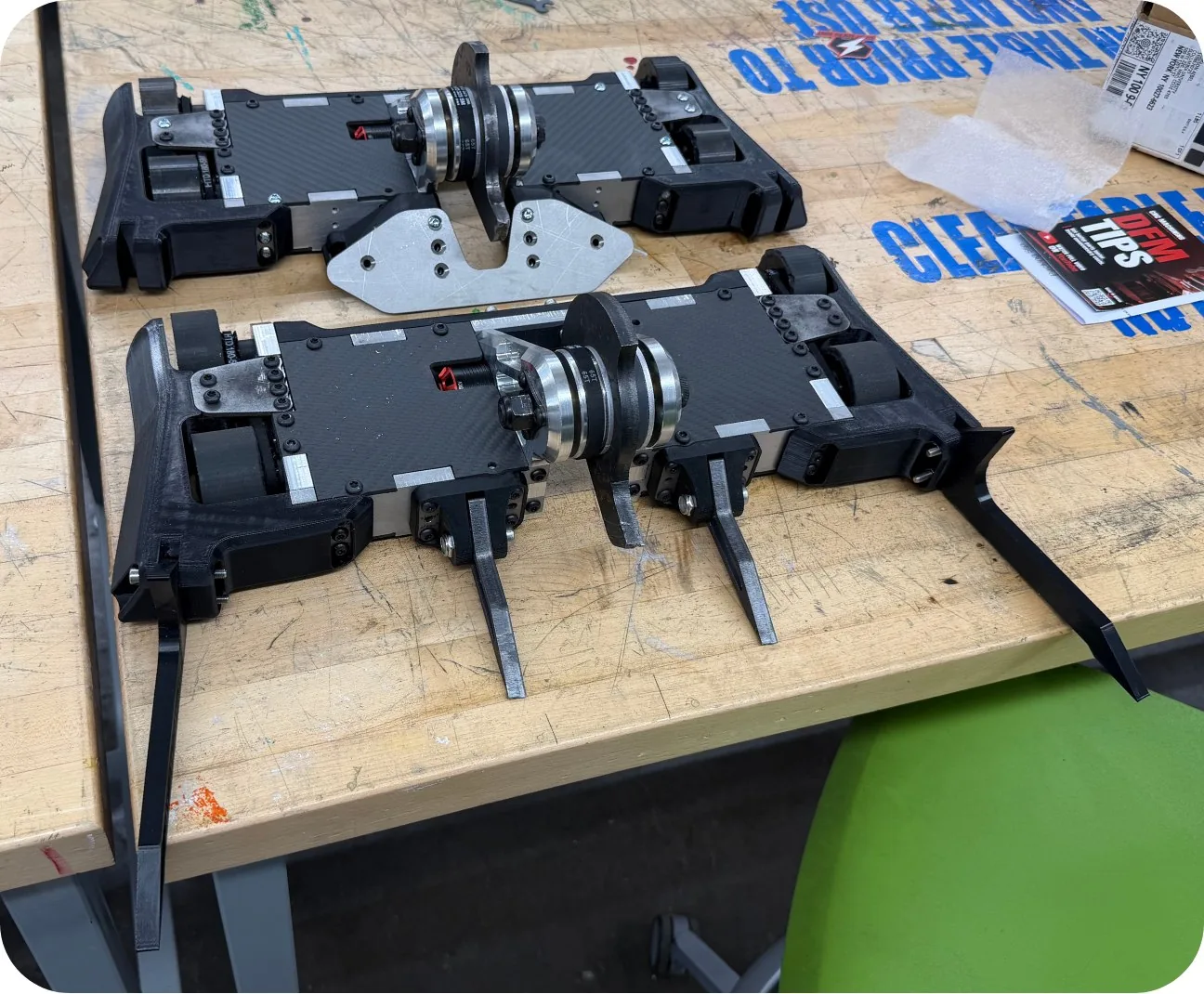 Two Combat Robotics fighting robots on a workshop table